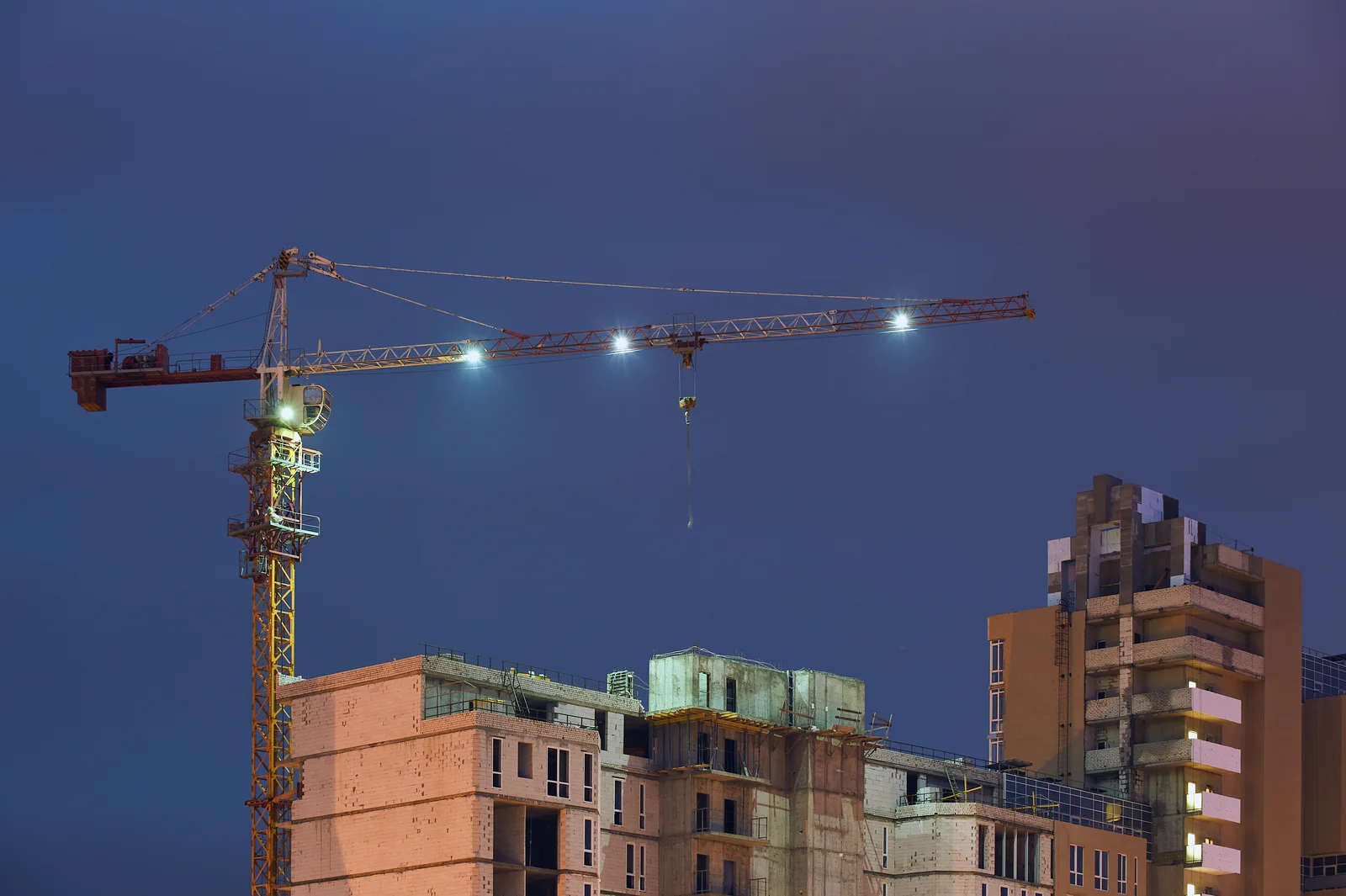 Canteiro de obras com guindastes à noite